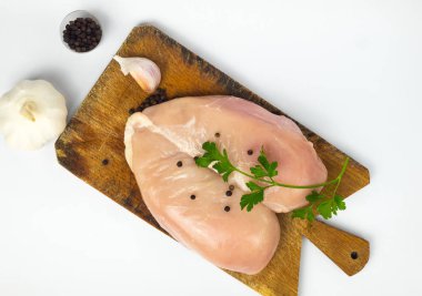 Çiğ tavuk göğsü ve baharatlar ahşap kesim tahtasının üzerinde, yakın görüş.