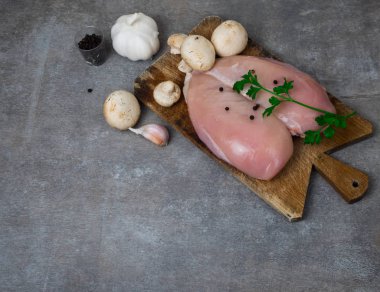 Çiğ tavuk göğsü fileto, ahşap tahta üzerinde baharatlar, beyaz tahta masa, üst görünüm, kopyalama alanı