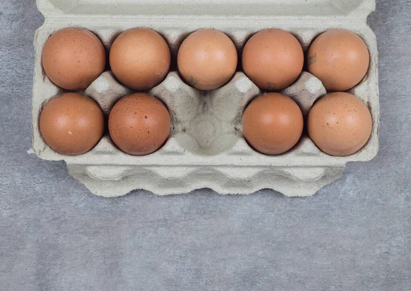 Plastic tray with eggs on a beton background, minimalism trend, top view