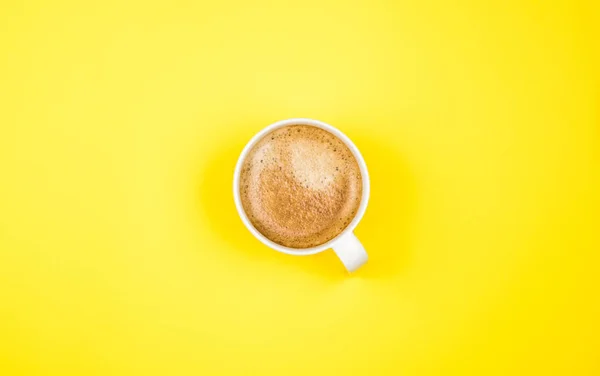 Ovanifrån bild av coffe cup på gul bakgrund. Ett platt ligg. Kopiera utrymme — Stockfoto