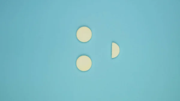 Bílé pilulky na modrém gradientu pozadí s kopírovacím prostorem v podobě úsměvu. Koncept farmakologie, vitamínů a pilulek pro děti. Pozitivní emoce. svislá fotografie — Stock fotografie
