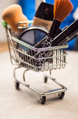 Alışveriş sepeti ile kozmetik, boncuk, eski ahşap arka plan üzerinde saç tokası. Tonlu görüntü