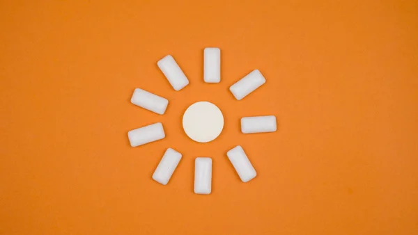 chewing gum on a light brown background. set out in the form of the sun