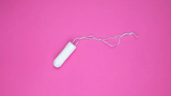 Medizinischer weiblicher Tampon auf rosa Hintergrund. Hygienischer weißer Tampon für Frauen. Wattestäbchen vorhanden. Menstruation, Mittel zum Schutz. Tampons auf rotem Hintergrund — Stockfoto