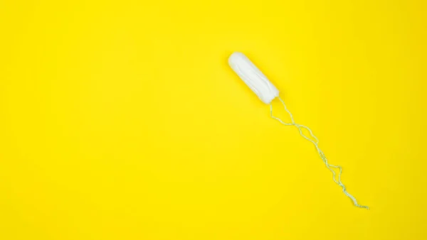 Medizinischer weiblicher Tampon auf gelbem Hintergrund. hygienischer weißer Tampon für Frauen. Wattestäbchen. Menstruation, Mittel zum Schutz. Tampons auf rotem Hintergrund — Stockfoto