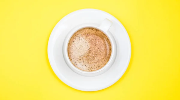 En kopp svart kaffe på gul bakgrund. Utsikt uppifrån. kopieringsutrymme — Stockfoto