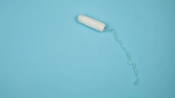 Medizinischer weiblicher Tampon auf blauem Hintergrund. hygienischer weißer Tampon für Frauen. Wattestäbchen. Menstruation, Mittel zum Schutz. Tampons auf rotem Hintergrund — Stockfoto