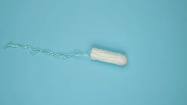 Tampón médico femenino sobre fondo azul. Tampón blanco higiénico para mujeres. Un hisopo de algodón. Menstruación, medios de protección. Tampones sobre fondo rojo —  Fotos de Stock