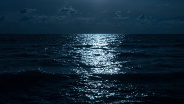 O reflexo da luz na água à noite — Fotografia de Stock