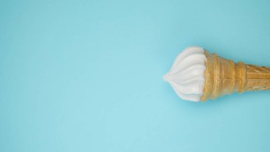 Vanilyalı dondurma koni mavi soluk pastel renk arka plan üzerinde. Vanilyalı gofret Kupası