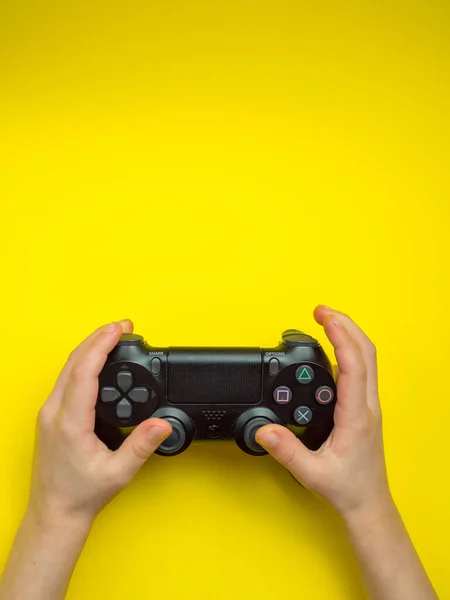 Ps Spiel Steuerknüppel. in den Händen eines Teenagers auf gelbem Hintergrund — Stockfoto
