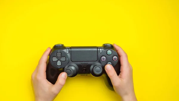 Ps παιχνίδι joystick. στα χέρια ενός εφήβου σε κίτρινο φόντο — Φωτογραφία Αρχείου