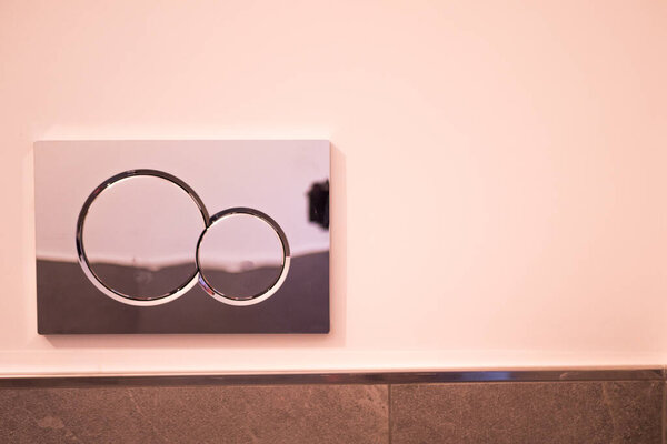 Economic toilet flush press with two separate buttons. Flushing water using dual machanism of concealed toilet cistern. Modern bathroom elements.