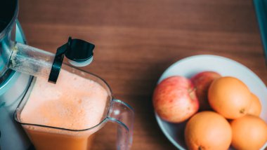 Taze portakal suyu hazırlama adam. Ahşap masa üzerinde arka planda meyve