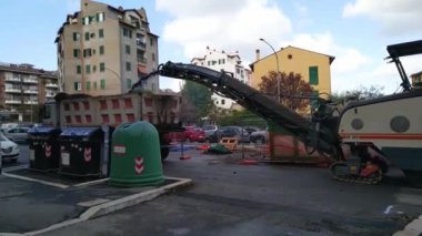 Yol onarımı, araba eski asfaltı yırtıyor.