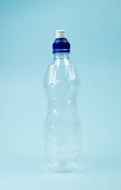Plastik içecek şişesi mavi arka planda izole edilmiş.