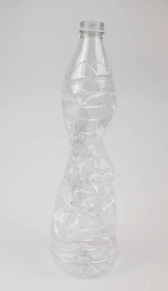 Les bouteilles en plastique utilisées sont broyées et écrasées sur un fond blanc. Concept de recyclage — Photo