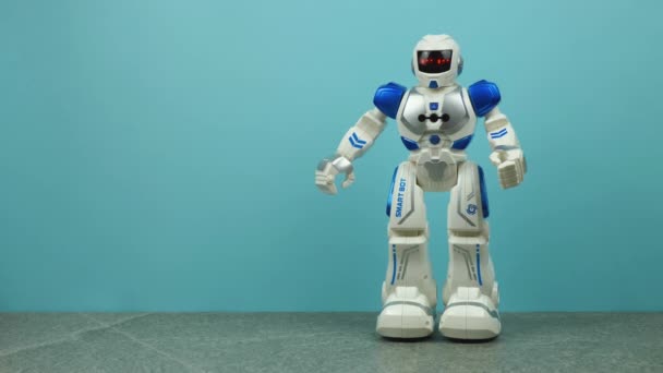 Oyuncak robot mavi arka planda dans ediyor. — Stok video