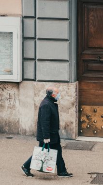 Roma, İtalya - 13 Mart 2020. Bulaşıcı hastalıklara karşı koruyucu maskeli bir adam ve kirlenme ve gribe karşı bir koruma olarak. Salgın Coronavirüs COVID-19 Roma