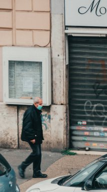 Roma, İtalya - 13 Mart 2020. Bulaşıcı hastalıklara karşı koruyucu maskeli bir adam ve kirlenme ve gribe karşı bir koruma olarak. Salgın Coronavirüs COVID-19 Roma