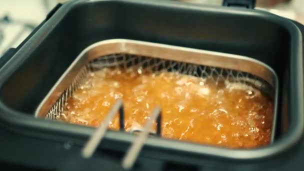Готовить жареного цыпленка. Закрыть жареные куриные наггетсы во фритюрнице в горячем масле — стоковое видео