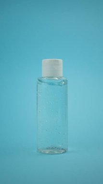 Mavi arka planda el yıkama için alkol jeli. Kirliliğe, virüse, gribe ve koronavirüse karşı koruma. Sağlık ve tıbbi konsept. Boşluğu kopyala.