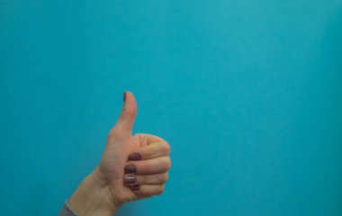 Kadın elleri sembol ve jestler gösterir. Mavi arka planda elleri izole edilmiş jestler. Boşluğu kopyala