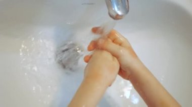 Bebek ağır çekimde ellerini yıkıyor. Seçici odak