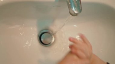 Lavaboda el yıkama jeliyle ellerini yıkayan tatlı bir çocuk. Temiz el konsepti. Sağlık hizmetleri Coronavirus koruması