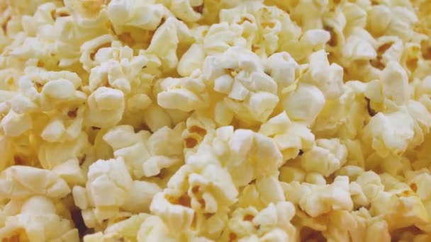 Popcorn obracający się z bliska, przewiewna kukurydziana przekąska serwowana w kinie, rozrywka. Tło popcornu. Popcorn obraca się powoli — Wideo stockowe