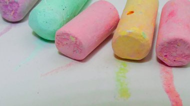 Farklı renkler çizmek için boya kalemlerine odaklan. Farklı renklerde asfalt üzerine çizim yapmak için seçici odak noktası.