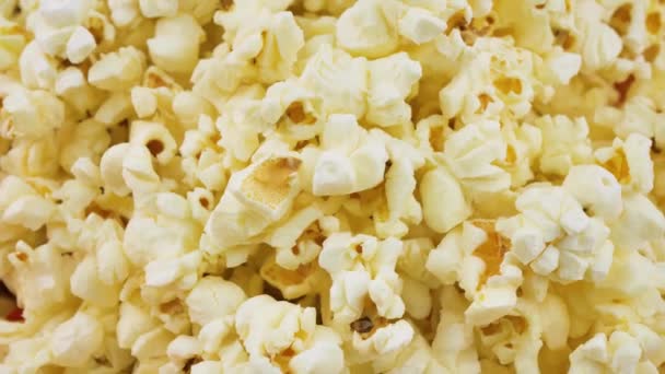 Popcorn περιστρεφόμενο κοντινό πλάνο, ευάερο ποπ κορν σνακ σερβίρεται στον κινηματογράφο, ψυχαγωγία. Ιστορικό ποπ κορν. Το ποπ κορν γυρίζει αργά — Αρχείο Βίντεο
