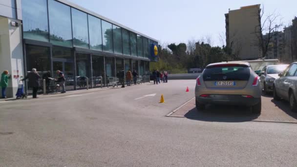 Roma, Italia. 20 de marzo de 2020 - Una cola de personas alineadas cerca de la tienda de comestibles Lidl con mucho espacio durante la crisis de Covid 192020, haciendo que los clientes se abastezcan de alimentos — Vídeos de Stock