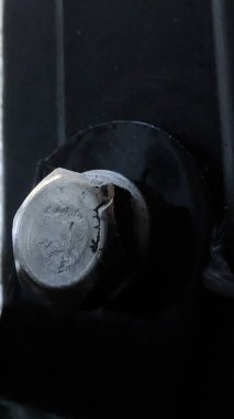 Siyah arka planda altıgen cıvatanın yüzü.