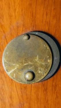 Kapalı kapı gözetleme deliği. Kahverengi meşe ağacından yapılmış ön kapıda çelikten bir yük arabası var..