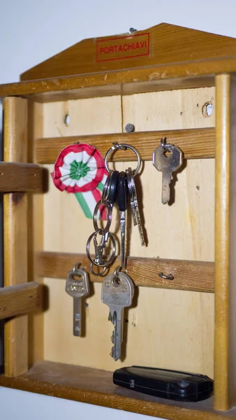 Wooden key box hangs on the wall. inscription in italian-key box.