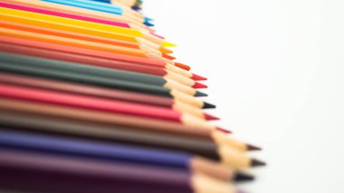 Beyaz arka planda izole edilmiş renkli boya kalemlerinin yakın çekimi.