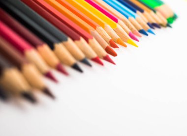 Beyaz arka planda izole edilmiş renkli boya kalemlerinin yakın çekimi.