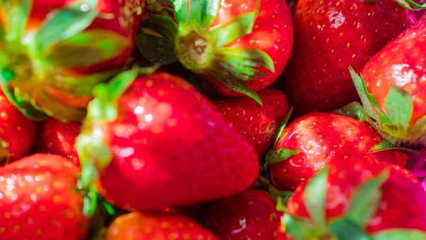 Street food, fresh strawberries, placed in a red basket.