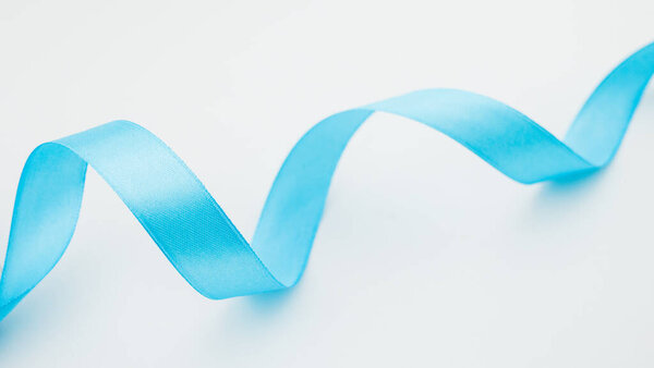 closeup of blue ribbon on white background.