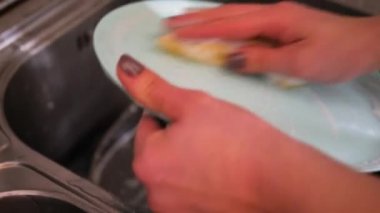 Ev ödevi: metal bir lavaboda bulaşıkları elle yıka. Bulaşıkları yıka. görünümü kapat