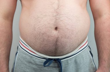 Erkeğin yağlı karnına dokunuşunu, Mens 'in aşırı göbek yağını tutuşunu. Aşırı kilolu olmak, kalp hastalığı, felç, yüksek tansiyon gibi büyük hastalıkların başlıca nedenlerinden biridir.