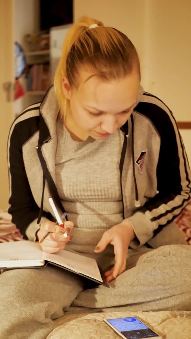 Chica joven estudiante de aprendizaje webcam chat en casa haciendo notas. El concepto de educación a distancia. vídeo vertical — Vídeo de stock