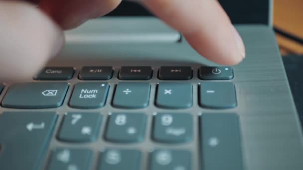 The man presses the power button and holds for a few seconds to shut down the computer — Stock Video