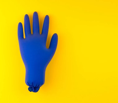 Sarı arka planda şişmiş mavi eldivenler. Konsept 2020 'de patlak veren bir salgın..
