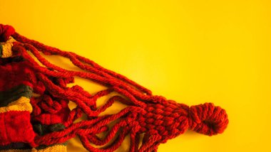 Örgü kumaş. Sarı arkaplanda kırmızı kabarık iplikler.