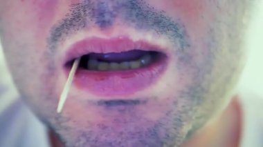 Ağzında kürdanla kameraya bakan yaratıcı, hoş, genç bir adam. Duygu kavramına çok yakın.