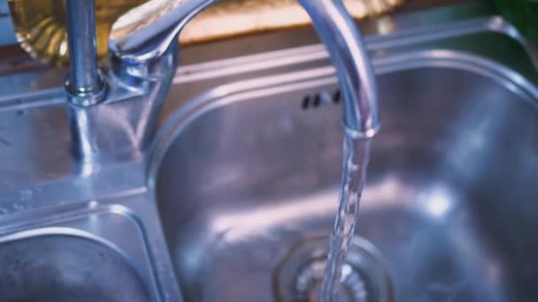 Homme recueille l'eau du robinet dans un verre — Video