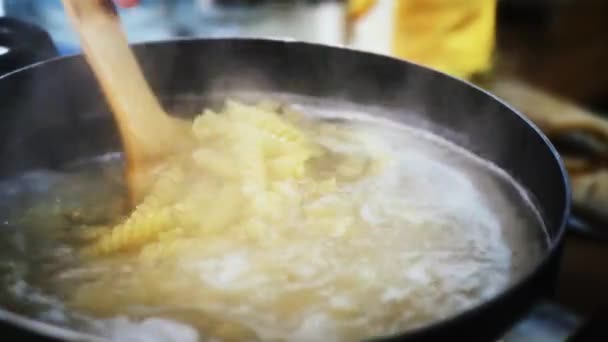 Паста, кипящая в кипящей воде в сковороде. Итальянская кухня. Закрыть макароны в кипящей воде — стоковое видео