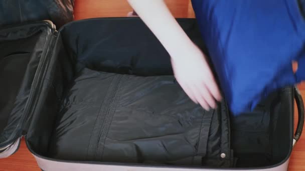 Mladá žena si vyzvedne kufr. Cestovatel se připravuje na cestu, osobní perspektivu, která vychází z věcí v chladném kraji — Stock video